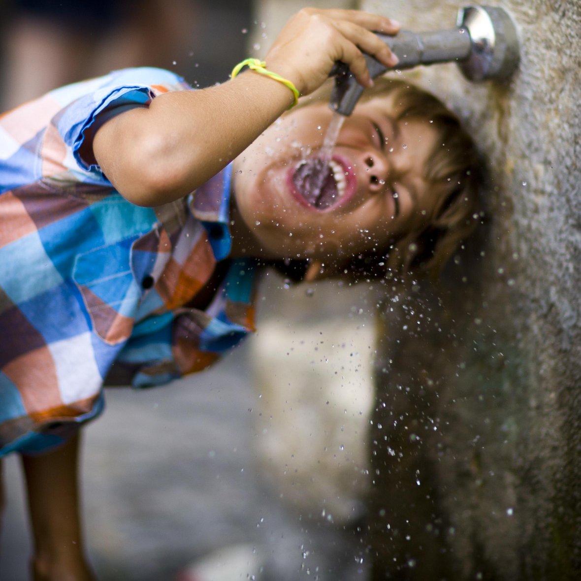 Kind trinkt aus Wasserhahn